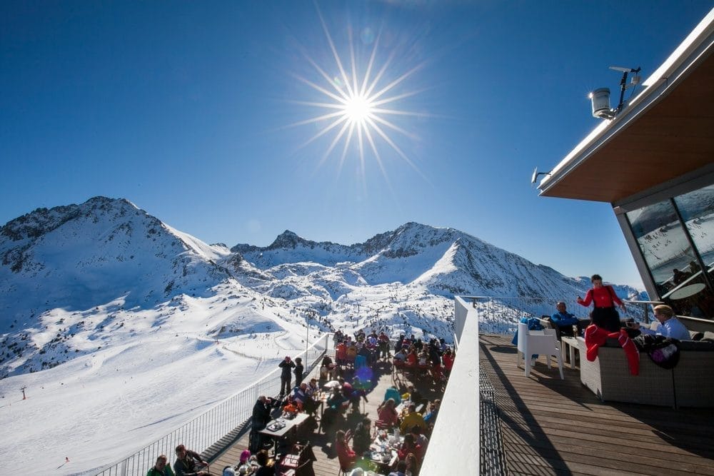 Sunny day at snowy ski resort with mountain view.